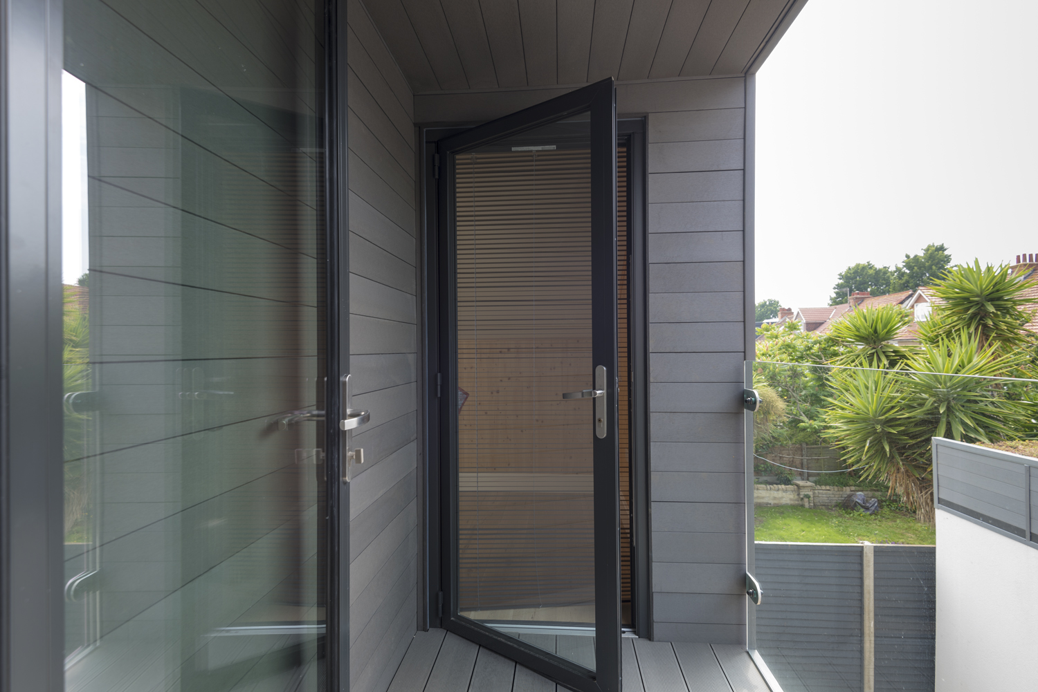 Half open see through door on a balcony of a modern house