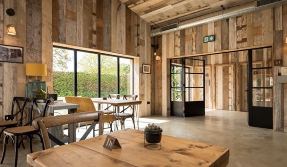 Bifold doors within a wooden cafe leading into a garden