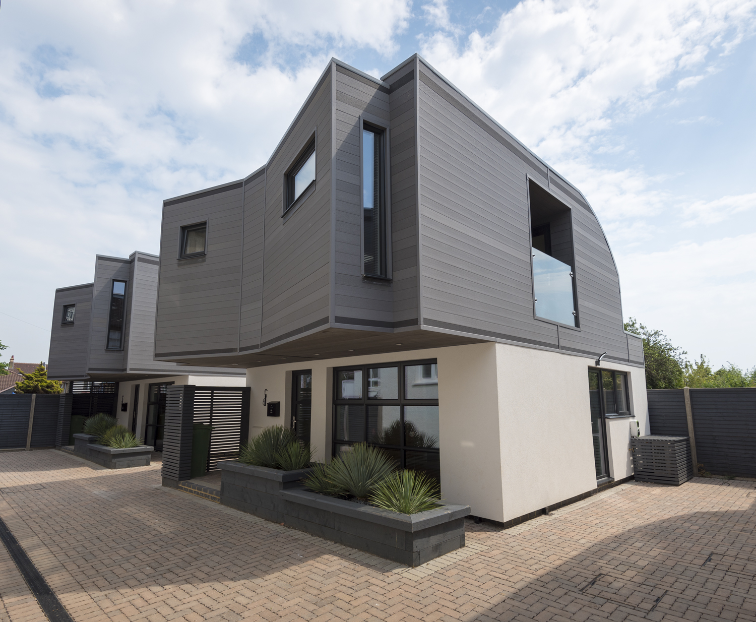 Full view of outside of a modern overhanging house